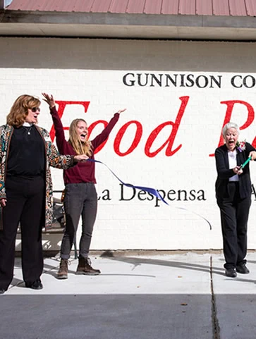 Ribbon Cutting Ceremony at the new Gunnison Country Food Pantry with Katie Dix cutting the ribbon.