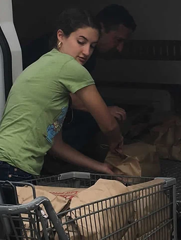 A GCFP volunteer loads groceries into a delivery van.