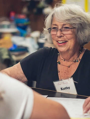 A Gunnison Country Food Pantry volunteer helping shoppers with a smile.
