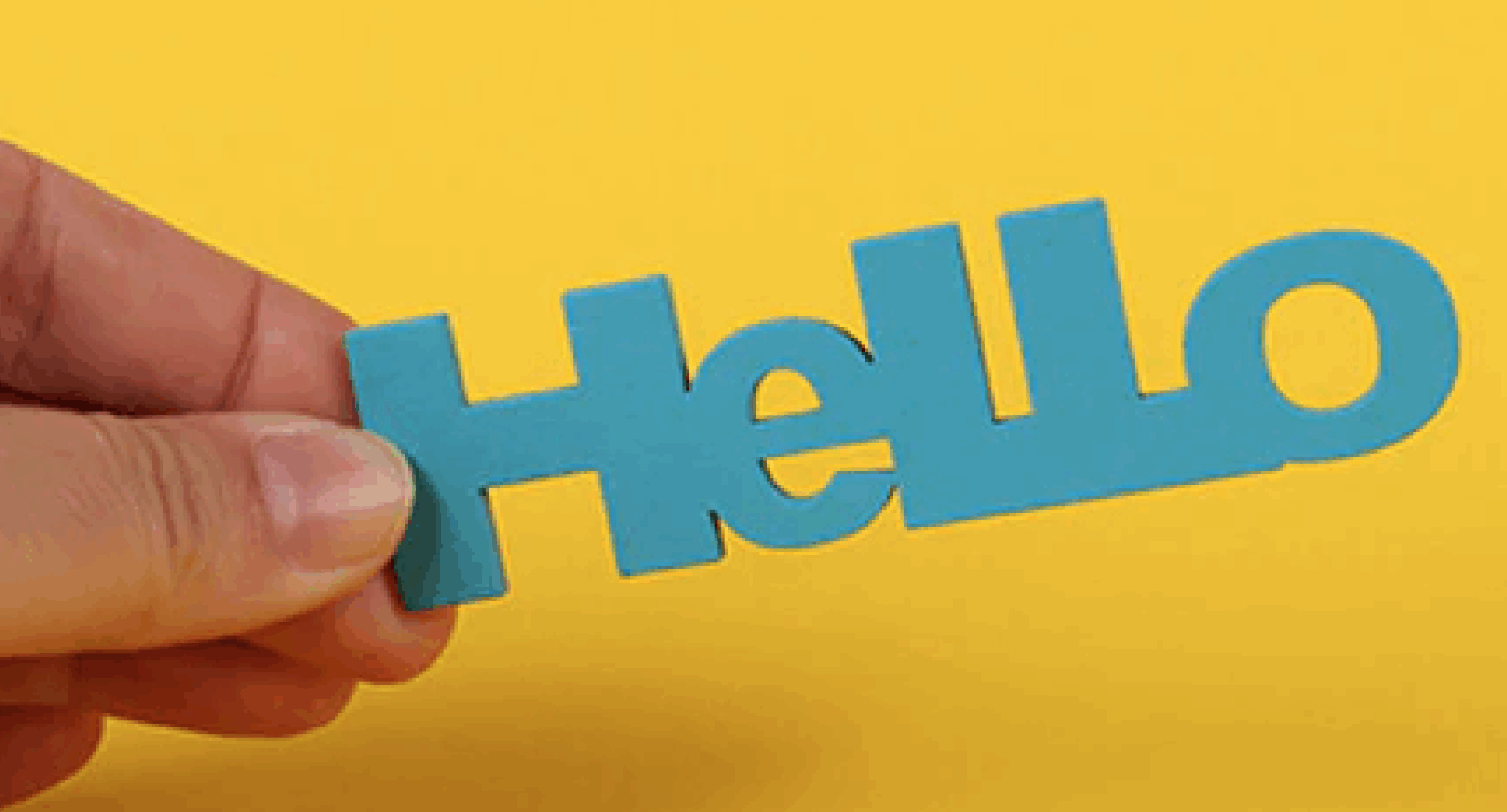 A hand holding a turquoise letters that say, "hello" against a bright yellow background.